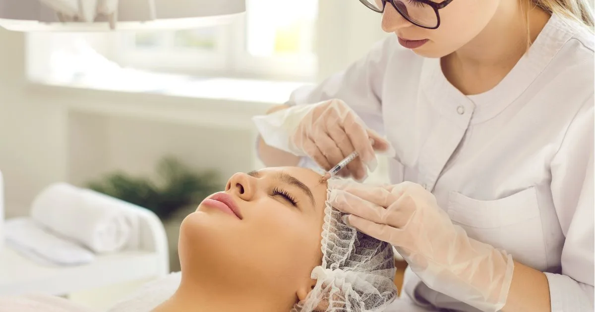 Close-up of a client receiving a precision skin treatment with a device, illustrating focused application of PRPPRFM.